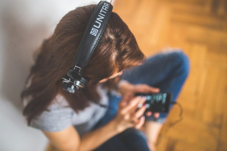Junge Frau mit Kopfhörer und Smartphone genießt Musik